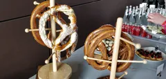 "Delicious giant pretzels hanging on racks on the buffet table."